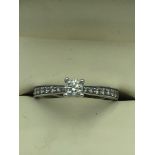 Platinum & diamond ring with central 4 claw set solitaire diamond with single cut diamond shoulders,