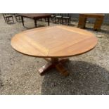 Honey coloured oak pedestal circular dining table with a drop side, hinged 152 dia x 76H