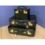 2 small black suitcases and 1 vanity case with Aston Martin Logo