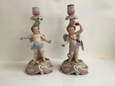 Pair of C19th Rudolstadt porcelain candlesticks, decorated with cherubs on naturalistic swagged,