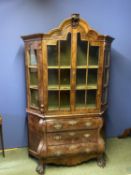 A good walnut Dutch bombe cabinet, with upholsteed shelves above 2 drawers on heavy ball and claw