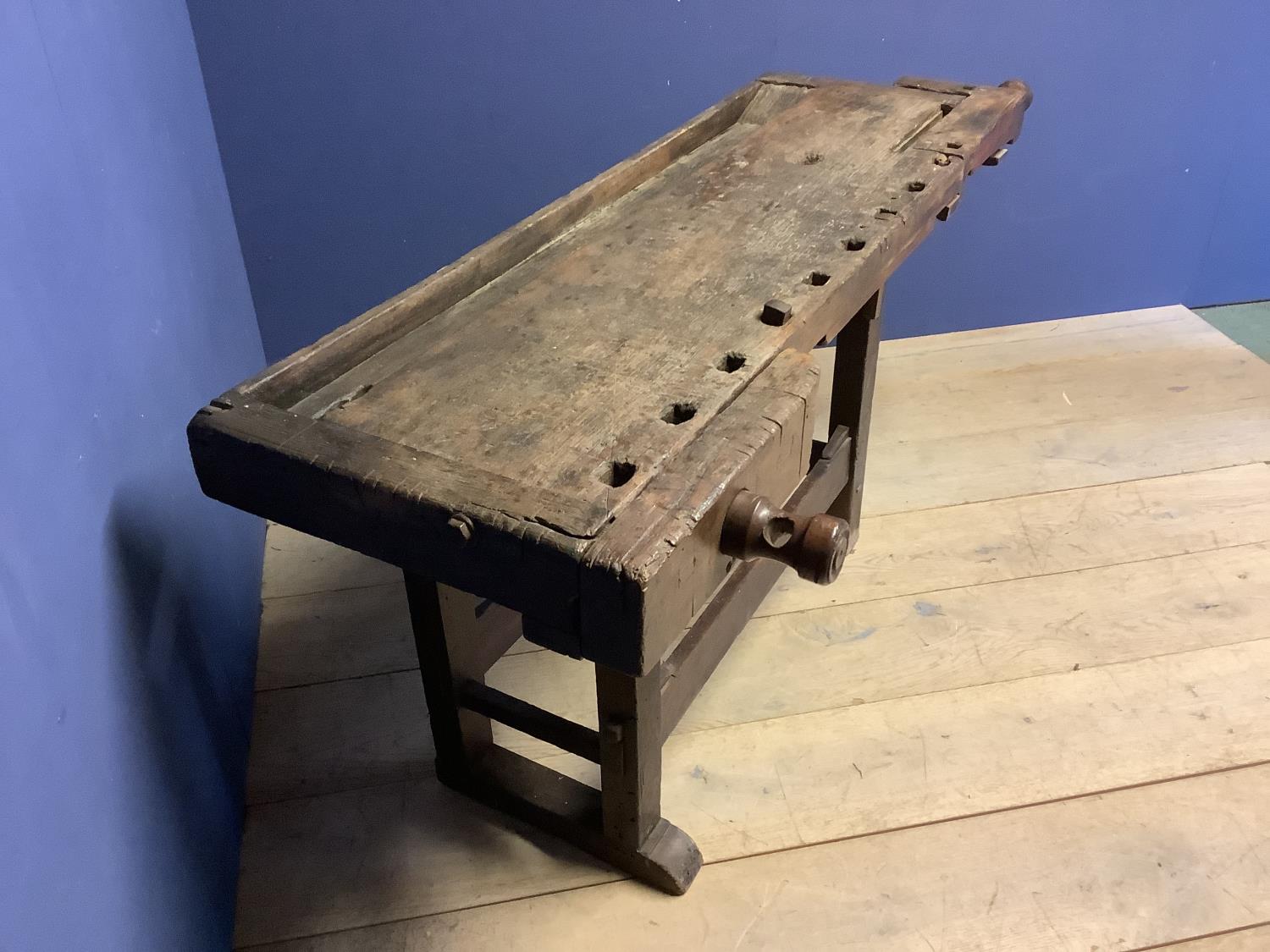 C18th rustic country made carpenter's work bench with wooden screw vice and metal pegs, approx 162