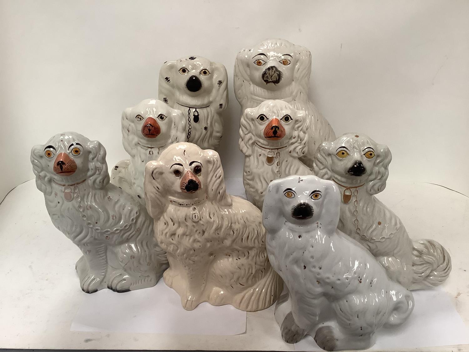 8 Staffordshire pottery dogs of spaniel type, late C19th/early C20th, heights ranging from 29cm-