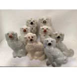 8 Staffordshire pottery dogs of spaniel type, late C19th/early C20th, heights ranging from 29cm-