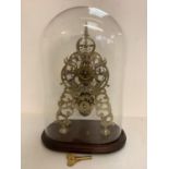 C19th brass skeleton clock complete with pendulum and key in a glass domed case, the clock 36cm H.