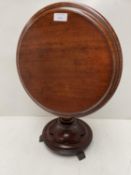 Mahogany circular tilt top table on column base to 3 paw feet, in the style of an apprentices piece,