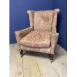 Upholstered (Paisley) arm chair on tapered mahogany legs with brass casters. Condition: worn, thread