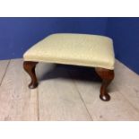 Small footstool upholstered in yellow fabric