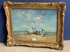Gilt framed oil on board painting of a Victorian beach gathering with beach huts & boats offshore.