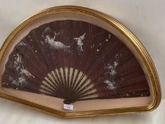 A glass cased fan, mounted and decorated with winged cherubs, approx. 62cm wide