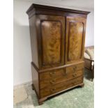 A good C19th flame mahogany linen press, with two doors above 2 short over 2 long drawers