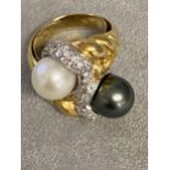 An impressive 18ct gold black and white pearl cross over ring, with central band of platinum mounted