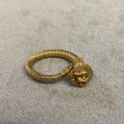 Unmarked yellow metal coil ring with lions head finial, 8.5grams, size M
