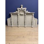 A modern, very decorative carved grey painted bed head in the classical style