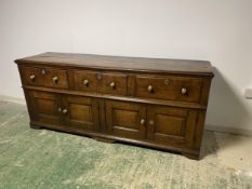 A good heavy oak side board, with 3 drawers, above 2 cupboard doors opening to reveal a curved