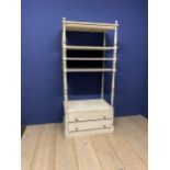 A grey painted shelving unit with 2 drawers to base, with decorative runed columns and finials