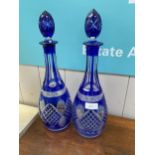 A pair of tall decanters, the glass decorated with blue insert panels and stoppers