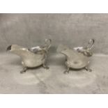 Pair Hallmarked Silver sauceboats with leaf capped scroll handles on cast shell feet by Mappin &