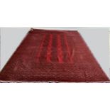 Bright red ground Persian Rug, with 18 geometric lozenges within a multi border 345cm x 250cm