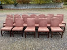 A set of 16 upholstered and brass studded substantial dining chairs, with swept back legs, the red