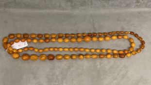 Large honey coloured amber graduated bead necklace, and a smaller honey coloured amber graduated