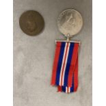 A WWII 1939-45 medal together with an antique worn copper coin, A red cased set of knife, fork