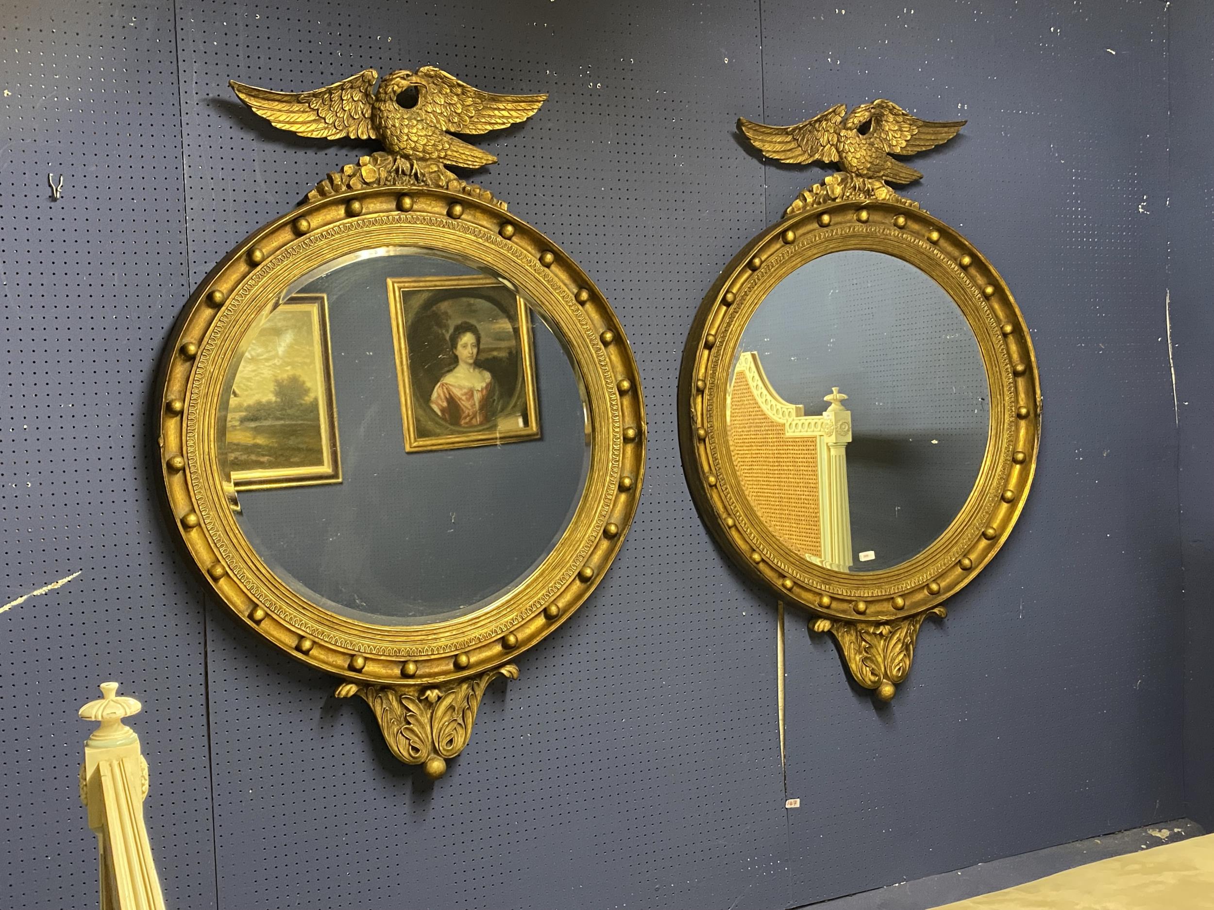 A pair of large handsome circular bevelled gilded wall mirrors, captain style, with ball decorations