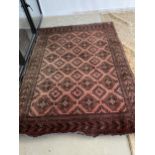 Persian style rug pink ground with all over geometric motifs in burgundy with darker oblong