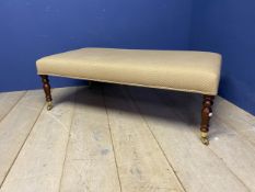 Contemporary oblong low upholstered stool on turned legs and castors 122x62x40 cm