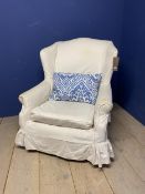 Traditional winged arm chair upholstered in white calico, and with loose cover