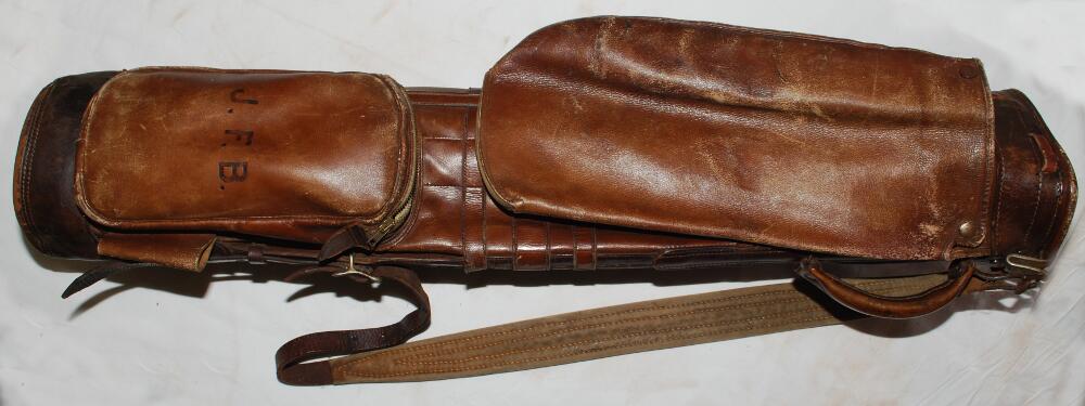Leather golf bag c.1915 with carrying strap and handle, hood and side pocket. Owner's initials 'J.