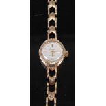 A lady's 9ct yellow gold Accurist manual wind wristwatch, having a round white baton dial and