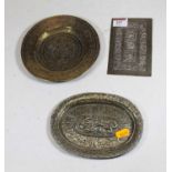 An early 20th century eastern brass dish of shallow form repoussee decorated with dragons amidst