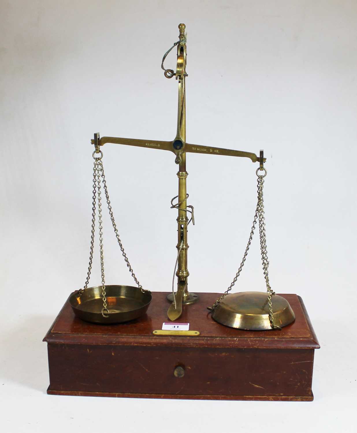 A pair of mid-20th century brass beam scales, marked Class B to weigh 5oz, on mahogany base with