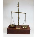 A pair of mid-20th century brass beam scales, marked Class B to weigh 5oz, on mahogany base with