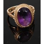 A 9ct yellow gold oval amethyst dress ring, the oval faceted amethyst within a rope edge border with