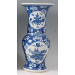 A Chinese export blue and white Gu vase, decorated with opposing reserves of objects amidst
