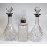 A pair of modern cut glass decanters and stoppers, each of pear shape with silver collar; together