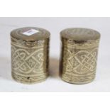 A pair of African white metal jars and covers, each of cylindrical form with incised geometric