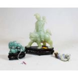 A reproduction Chinese faux jade figure carved as a man on the back of a dog of Fo, on further