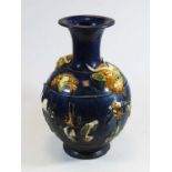 A Chinese style pottery vase, on a blue ground, having raised grotesque masks and horses, h.