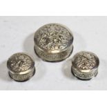 An Eastern white metal pill box, of circular form, the dome cover relief decorated with a flower;