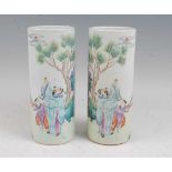A pair of Chinese vases each of cylindrical form, enamel decorated with two figures beneath a