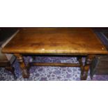 A 17th century style joined oak plank top refectory dining table, raised on turned and square cut