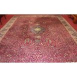 A large Persian style machine-woven red ground Tabriz carpet, having all-over floral ground, 453 x