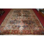A Persian woollen rug, the central ground decorated with two rows of floral medallions within