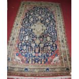 A Persian woollen blue ground rug, having a central medallion issuing flowers and foliage within