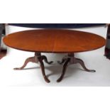 A 19th century mahogany twin pedestal dining table, the crossbanded top on gun barrel turned columns
