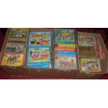 Four boxes of various jigsaws including Rupert the Bear, and various Victory puzzles