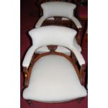 A pair of late Victorian walnut framed and upholstered tub parlour elbow chairs, each raised on ring